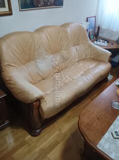 Kožni trosjed, dvosjed, fotelja i drveni sto.