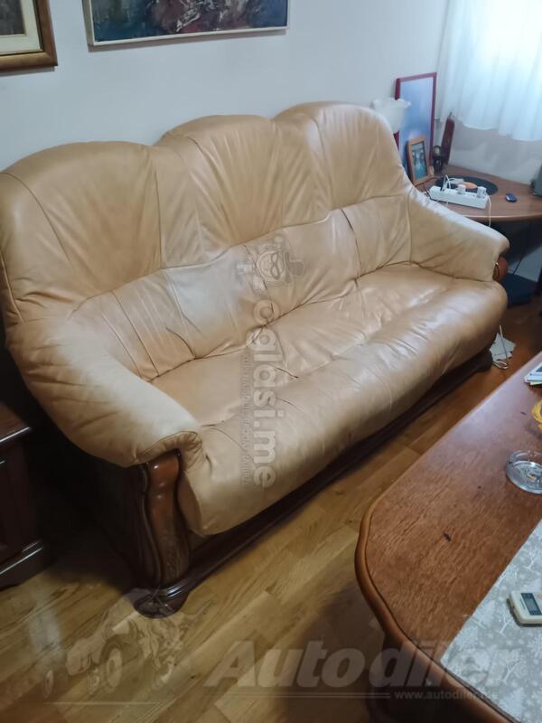 Kožni trosjed, dvosjed, fotelja i drveni sto.